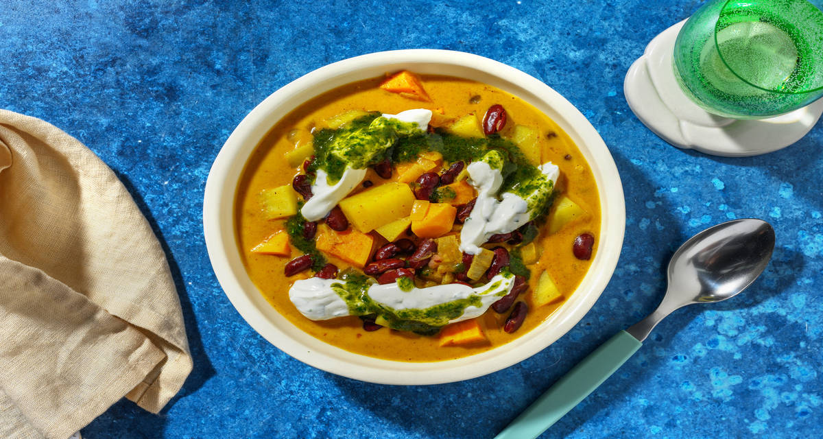 Curry de patata y boniato con judías con salsa de yogur y aceite de cilantro