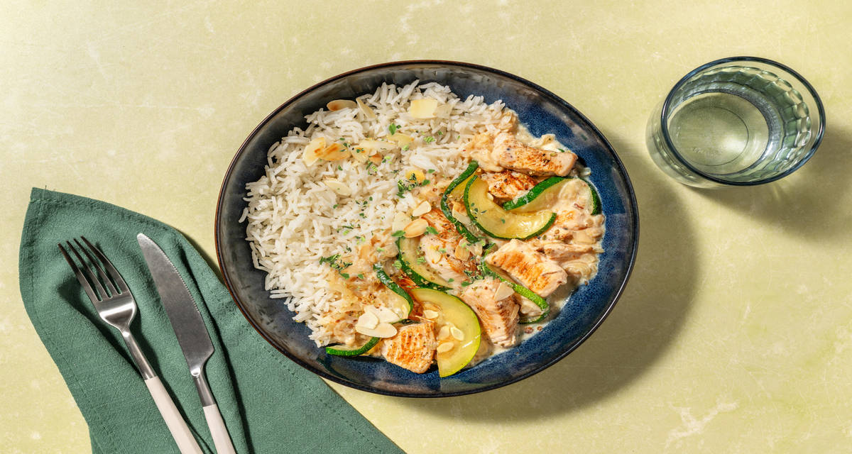 Dados de pollo en salsa cremosa de almendras con verduras y arroz
