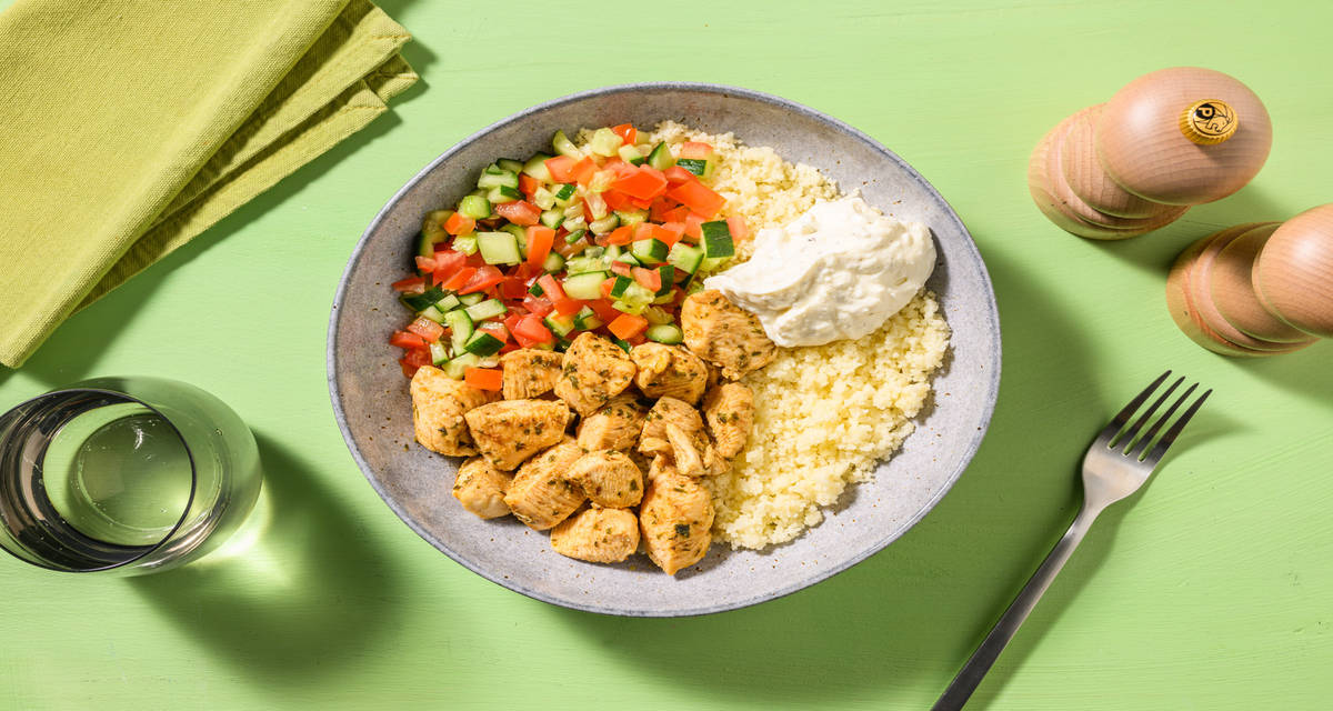 Bol de cuscús con pollo especiado con salsa de yogur griego y ensalada fresca