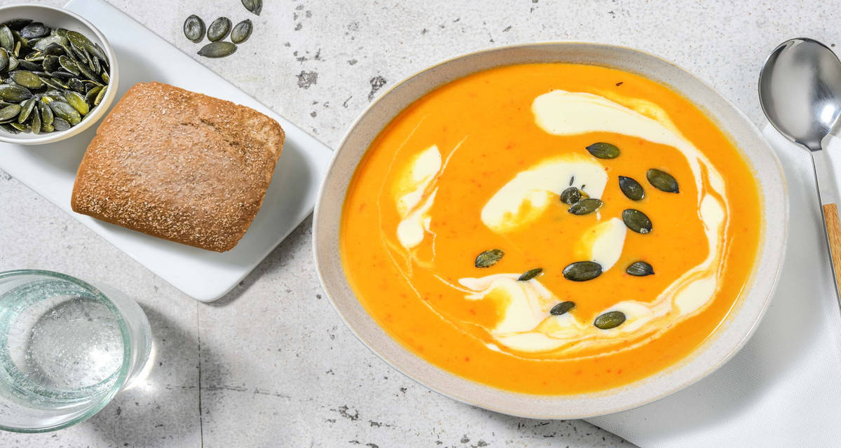 Maaltijdsoep met zoete aardappel en paprika met crème fraîche en maanzaadbroodje