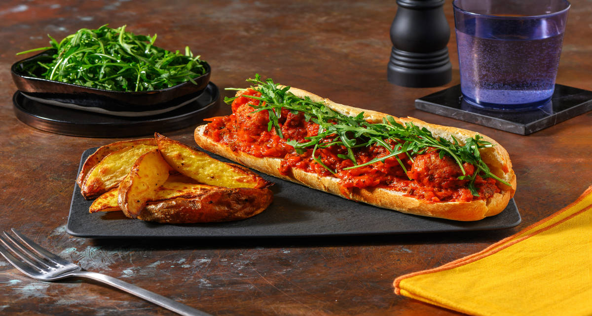 Bocadillo de albóndigas con pesto calabrese acompañado con patatas al pecorino y rúcula