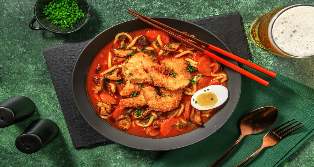 Zuppa di noodles al curry e gamberi fritti con ketchup, funghi shiitake e uova sode