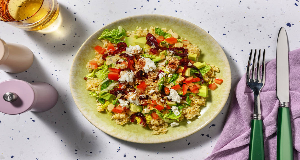 Salade boulgour, avocat & chèvre frais avec de la tomate & des amandes torréfiées