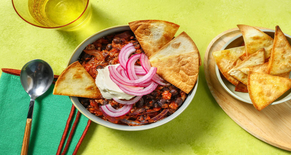 Mijoté de bœuf & haricots noirs à la texane avec des chips de tortillas & des pickles d'oignon