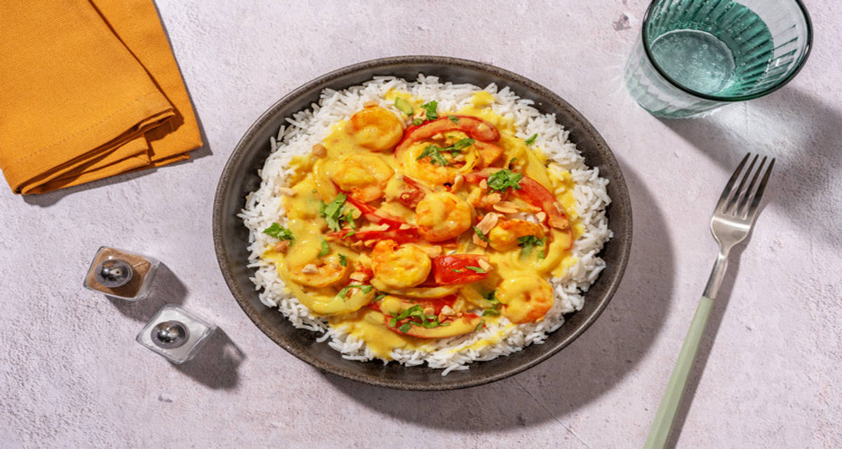 Scampi's in kokos-currysaus uit de oven met rijst, koriander en pinda's