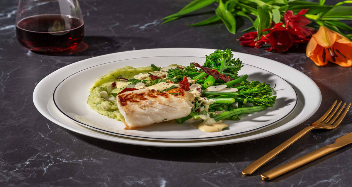 Kabeljauwfilet in beurre blanc met serranoham met kruidenpuree, broccolini, amandelen en sperziebonen