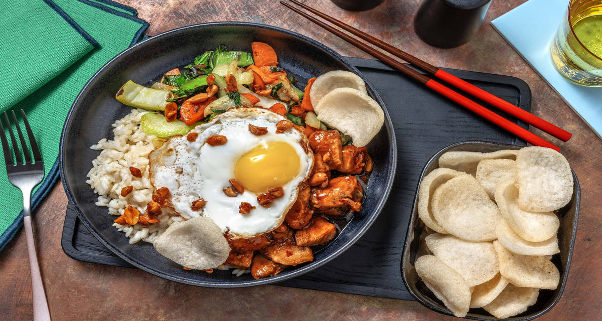 Poulet en sauce soja sucrée, œuf au plat et krupuk riz à l'ail, pak-choï et cacahuètes au miel piquantes