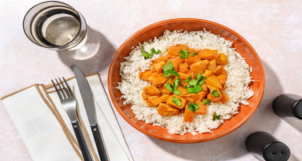 Curry massaman con dados de pollo con cilantro sobre arroz