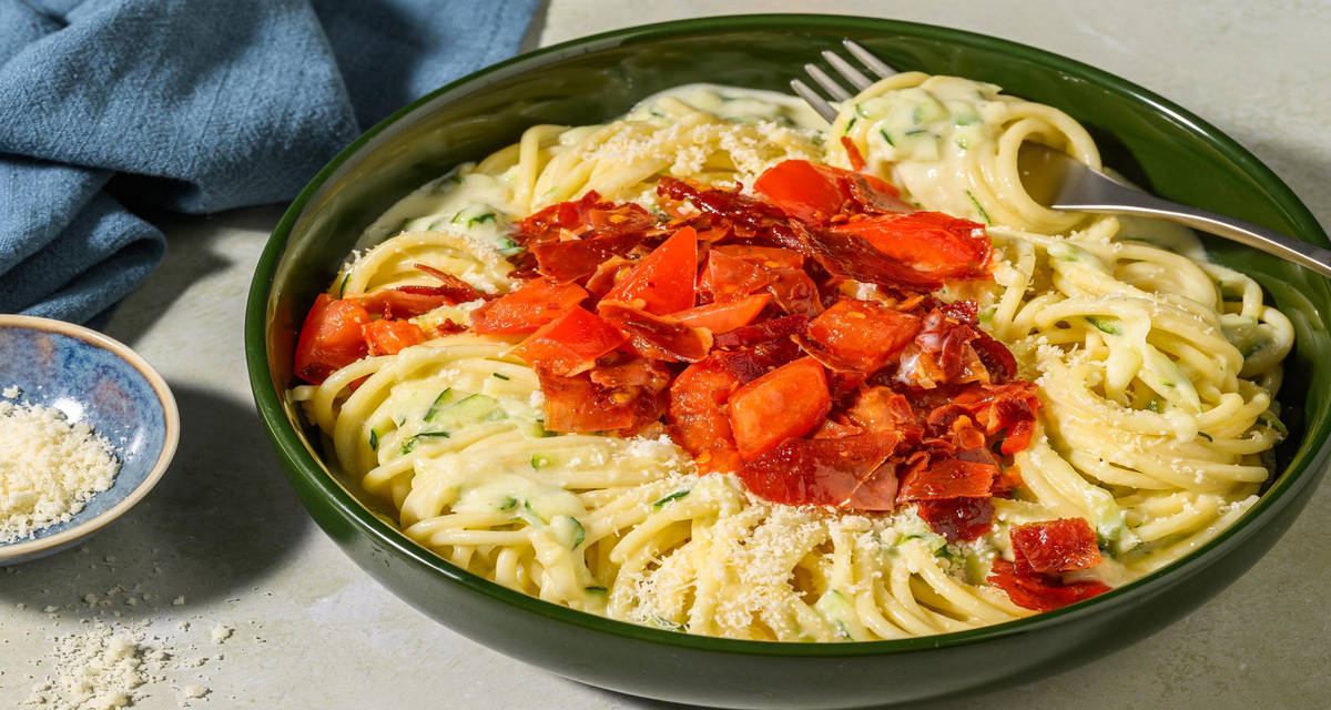 Cremet zucchinipasta og sprød prosciutto med sauteret tomat, hvidløg og chiliflager