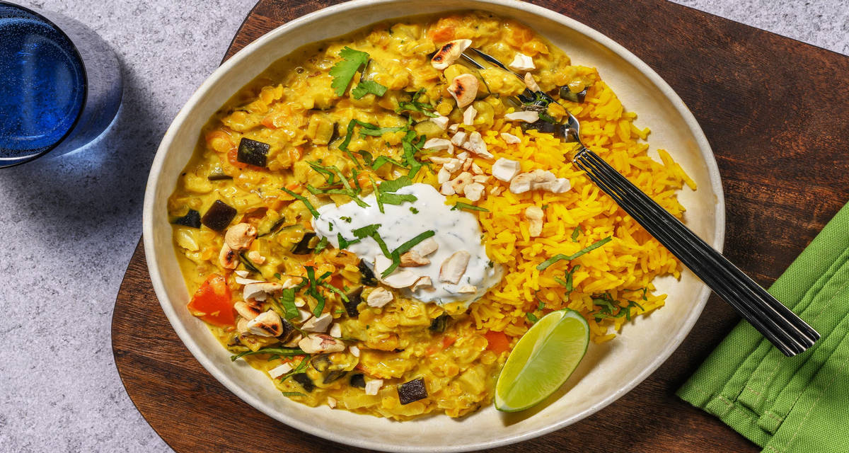 Masala piquant d'aubergine et de lentilles riz jaune, sauce yaourt au citron vert et noix de cajou