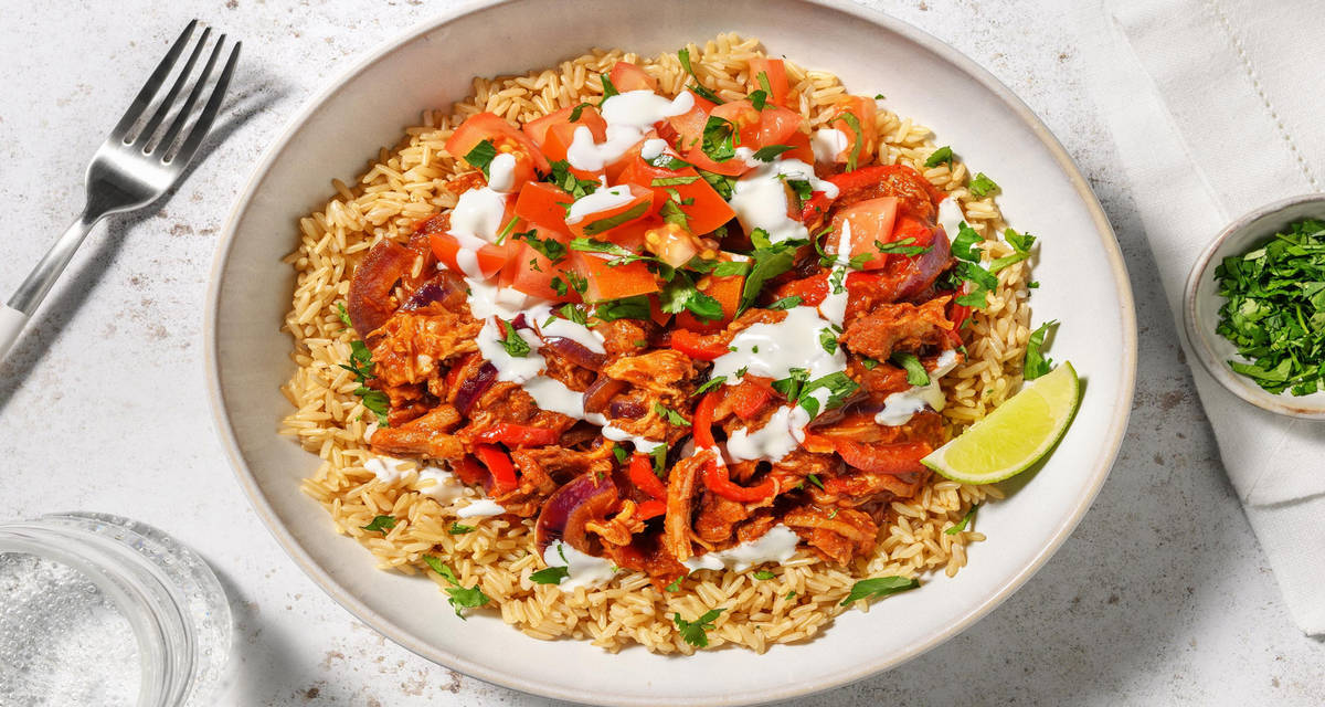 Smokey pulled-chickenbowl met chipotle met bruine rijst, tomatensalsa, yoghurt en puntpaprika