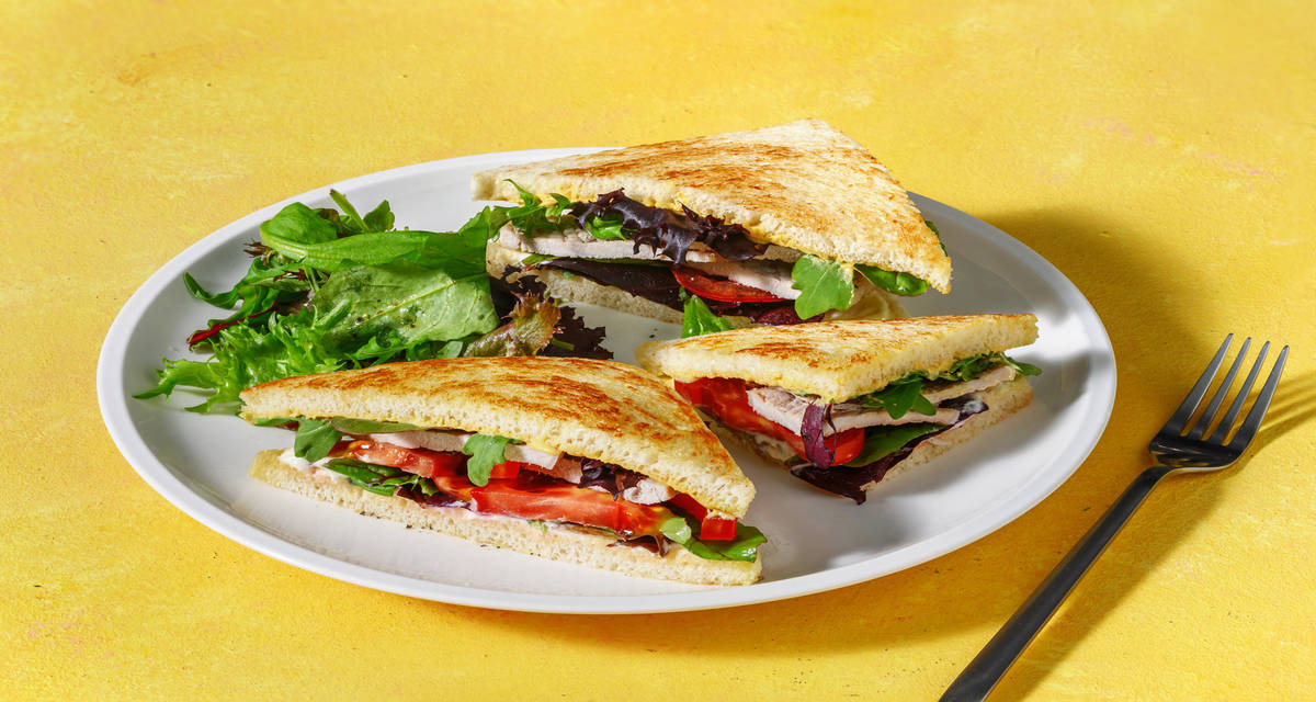 Sandwich di tagliata di pollo in stile Pastrami con pomodoro, salse golose e insalata