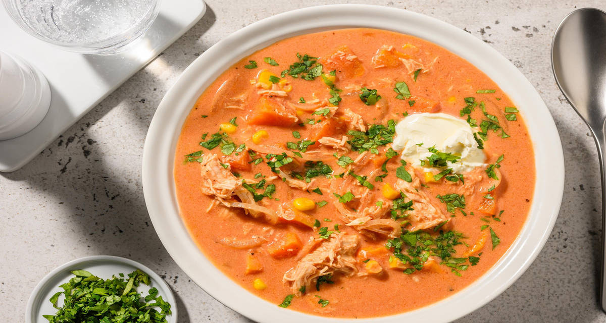 Pikante chipotle kippensoep met zure room, zoete aardappel, mais en koriander