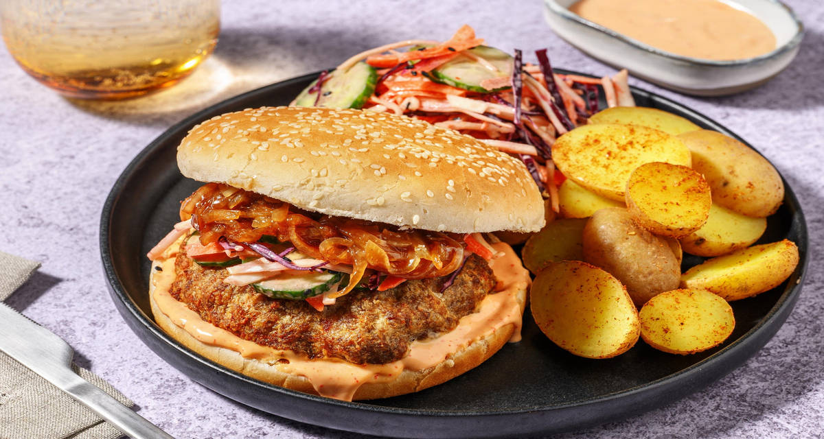Koreaans geïnspireerde bulgogiburger met sriracha-mayo met kimchi-regenboogsla, sesamzaadjes en pikante patatjes