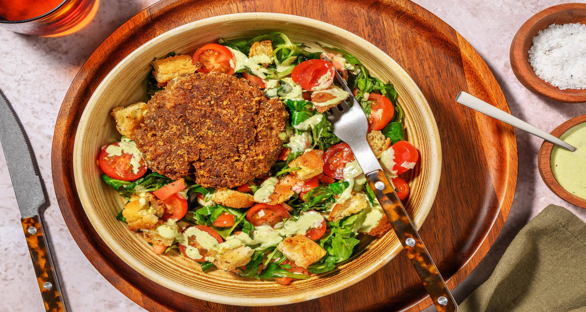Italiaans geïnspireerde bowl met plantaardige visburger met basilicummayo, ciabattacroutons, kerstomatensalade en rucola