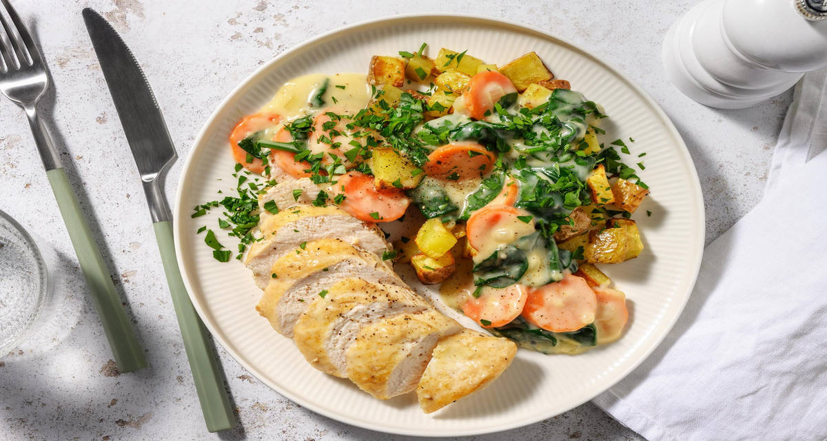 Kipfilet in spinazie-roomsaus met gebakken patatjes, wortel en verse kruiden