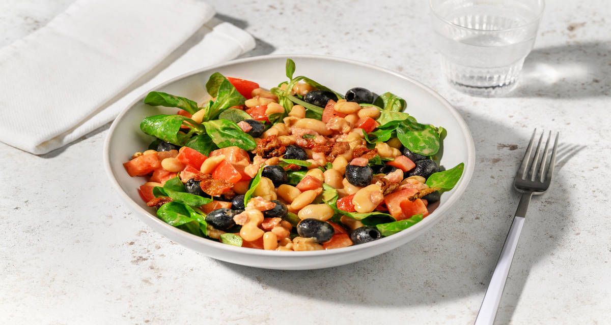 Ensalada de judías blancas, bacon y tomates secos con olivas negras y vinagreta de mostaza y miel
