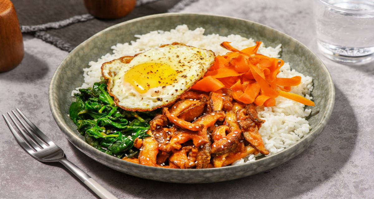 Bibimbap di carne piccante e funghi alla coreana con riso bianco, spinacini e salsa allo zenzero