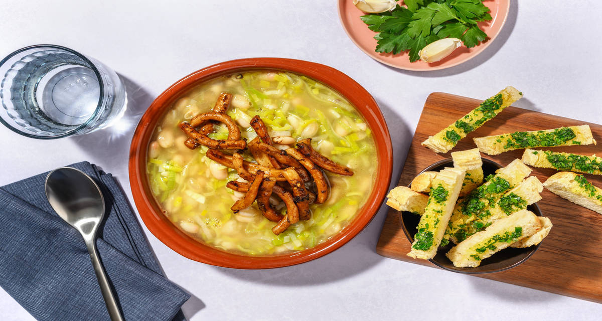 Guiso de judías con calamar gigante caramelizado con pan de ajo y perejil