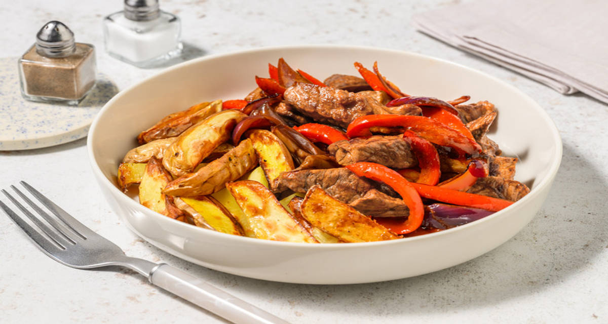 Lomo adobado saltado al estilo peruano con patatitas al horno