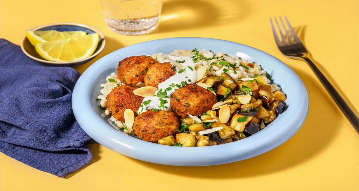 Boulettes de porc épicées & couscous perlé avec des aubergines & une sauce yaourt