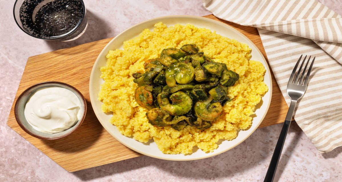 Crevettes, zhoug à la coriandre & semoule avec des courgettes, du curry & du labneh
