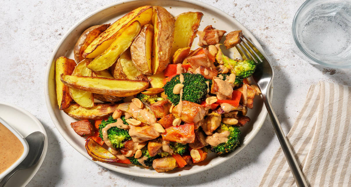 Pindatastische traybake met varkenshaas met patatjes, nasi-bamikruiden en broccoli