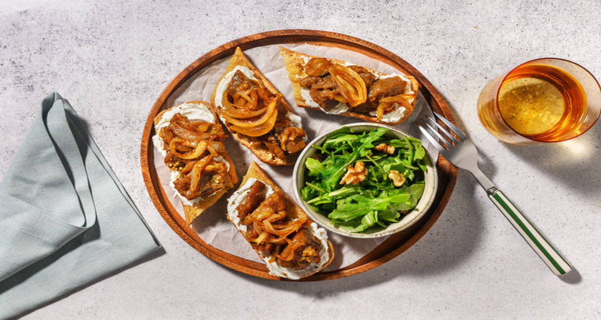 Tostadas de berenjena mechada con queso de cabra con cebolla caramelizada y ensalada con nueces