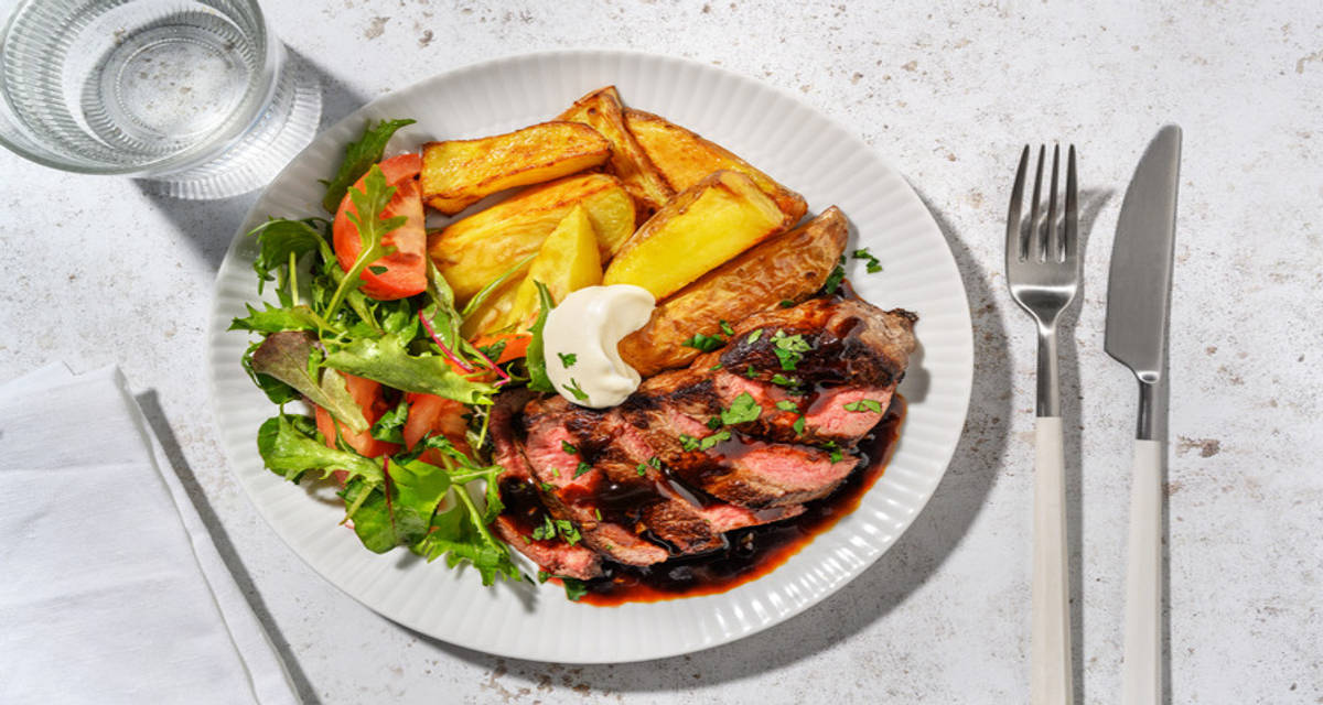 Steak et sauce à l'ail, mesclun pommes de terre sautées, radis, tomate et persil