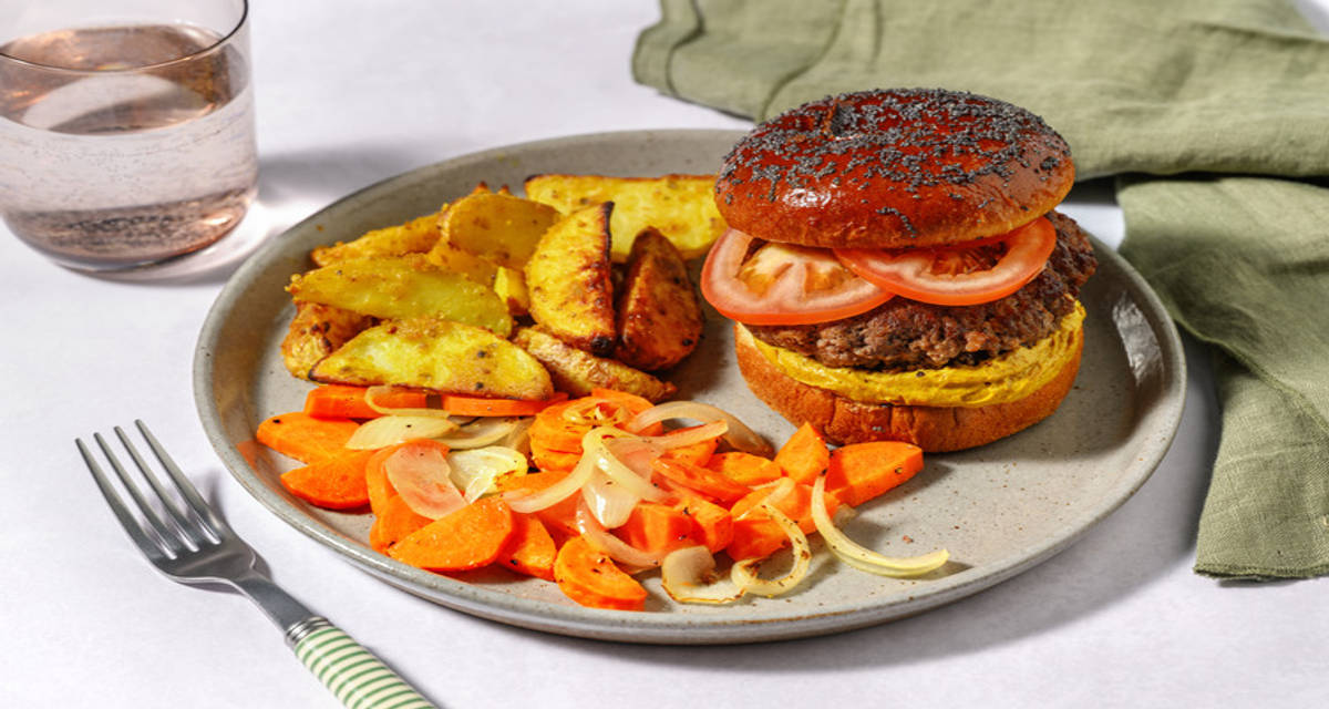 Burger picante con salsa de curry massaman con patatas deluxe al curry y verduritas asadas