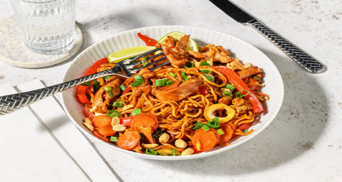 Hoisin-noedels met kip en gebakken groenten met lente-ui en pinda's