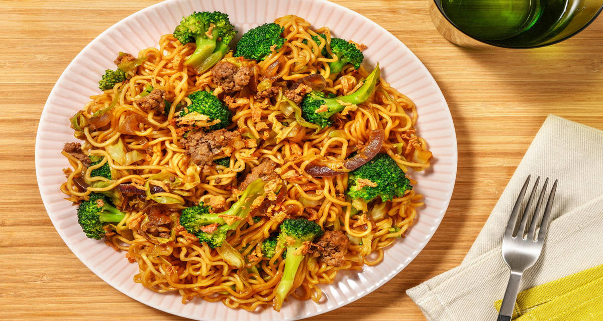 Stir-fry met noedels, rundergehakt en gefrituurde uitjes met zoete Aziatische saus, spitskool en broccoli