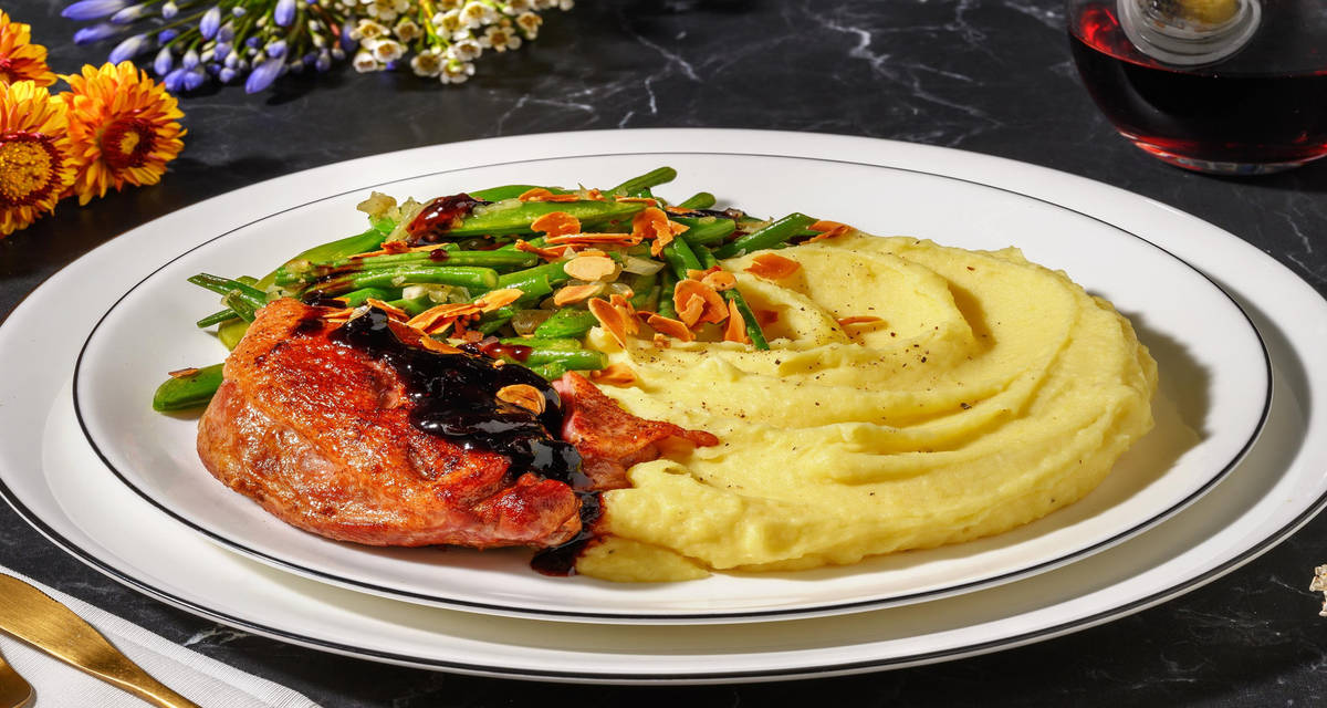 Gekonfijte eend met bosbessensaus en amandelen met aardappelpuree, Parmigiano Reggiano en groene groenten