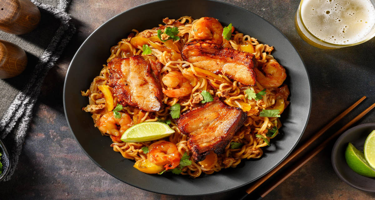 Nouilles à la singapourienne aux crevettes et poitrine de porc façon Hokkien mee, oignons frits et citron vert