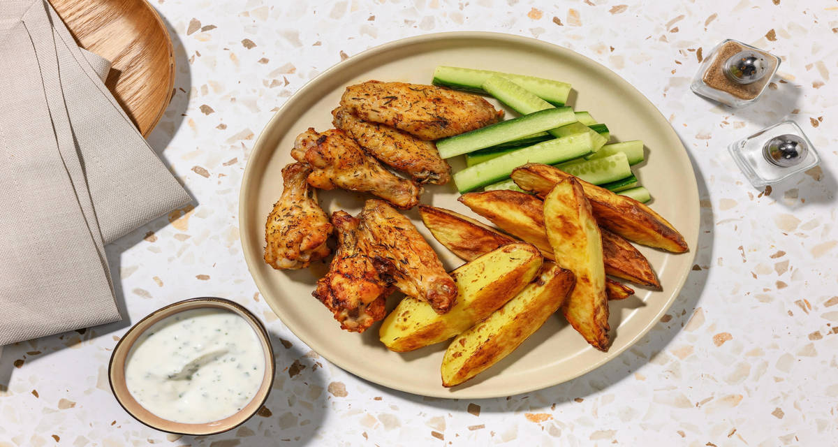 Buffalo wings: nuestras alitas de pollo picantes con patatas, salsa de yogur y cebollino y pepino