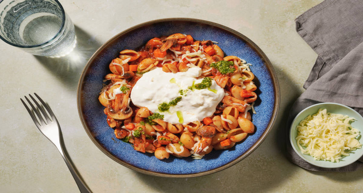 Conchiglie met burrata, pesto en mozzarella in tomaat-champignonsaus met Siciliaanse kruiden