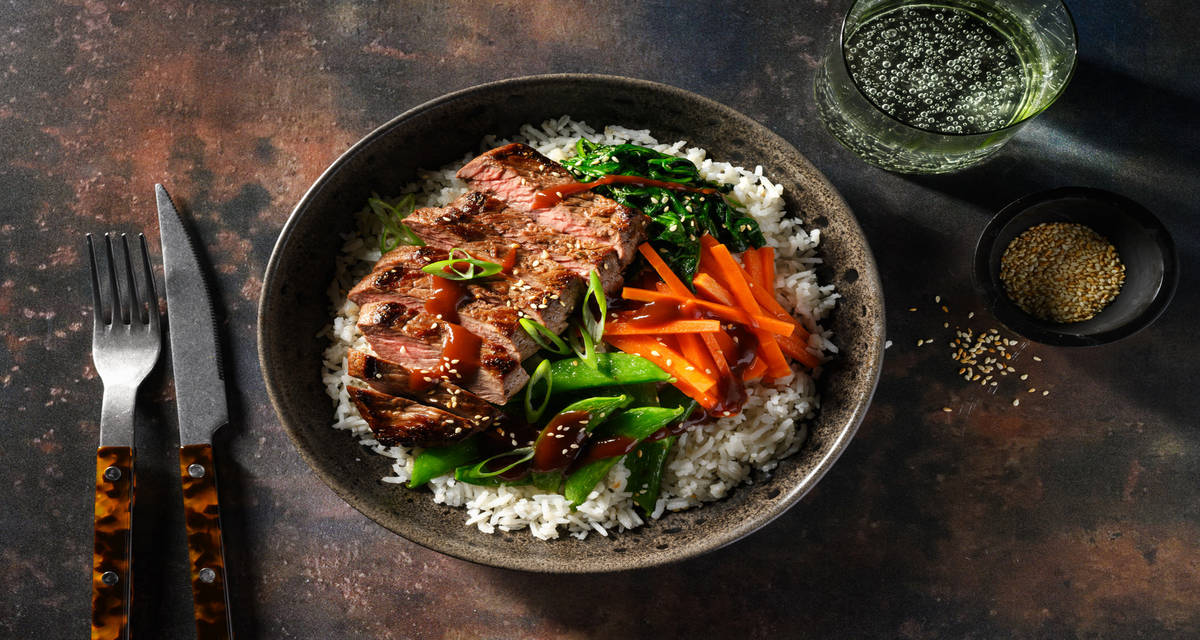 Bibimbap-stijl bowl met bavette en gochujang-glaze met rijst, sesam-spinazie en sugarsnaps