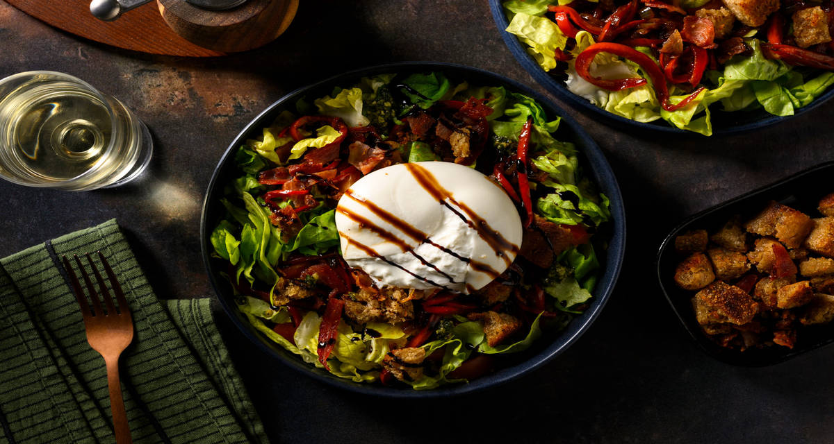 Salade met burrata, spek, basilicumcrème en croutons met balsamicocrème, botersla en paprika