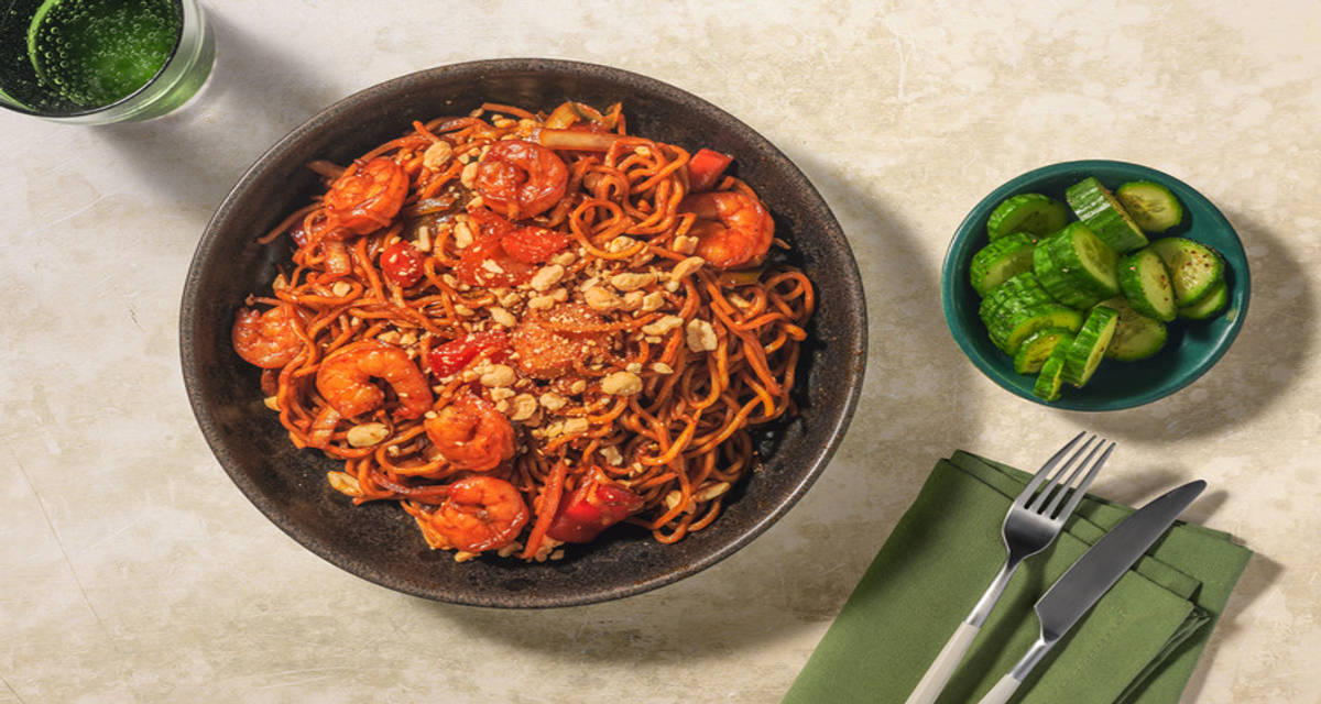 Stir-fry met gamba's, oestersaus en noedels met gemengde groenten, komkommer en pinda's