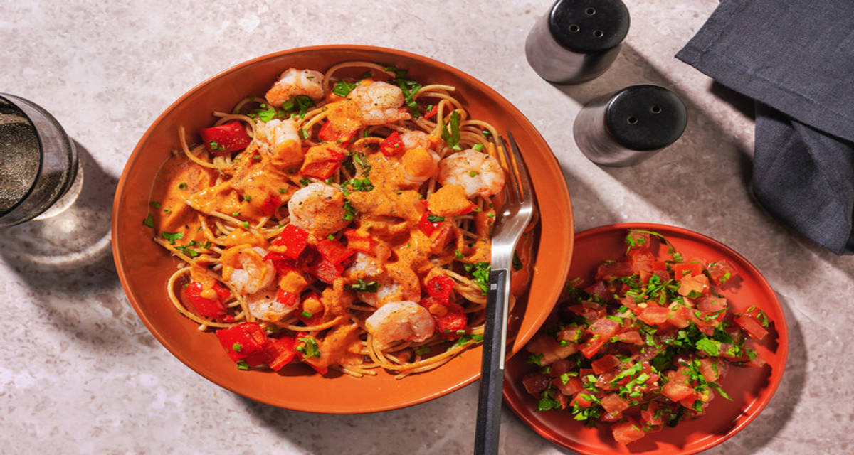 Spaghetti aux crevettes en sauce crémeuse au curry poivron pointu rôti, salade de tomate et herbes fraîches