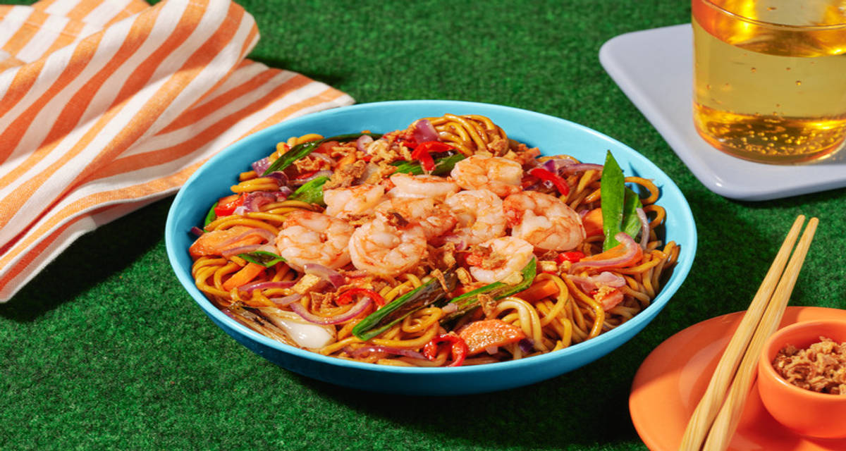 Stir-fry met scampi's en noedels met gemberwoksaus, groenten en gefrituurde uitjes