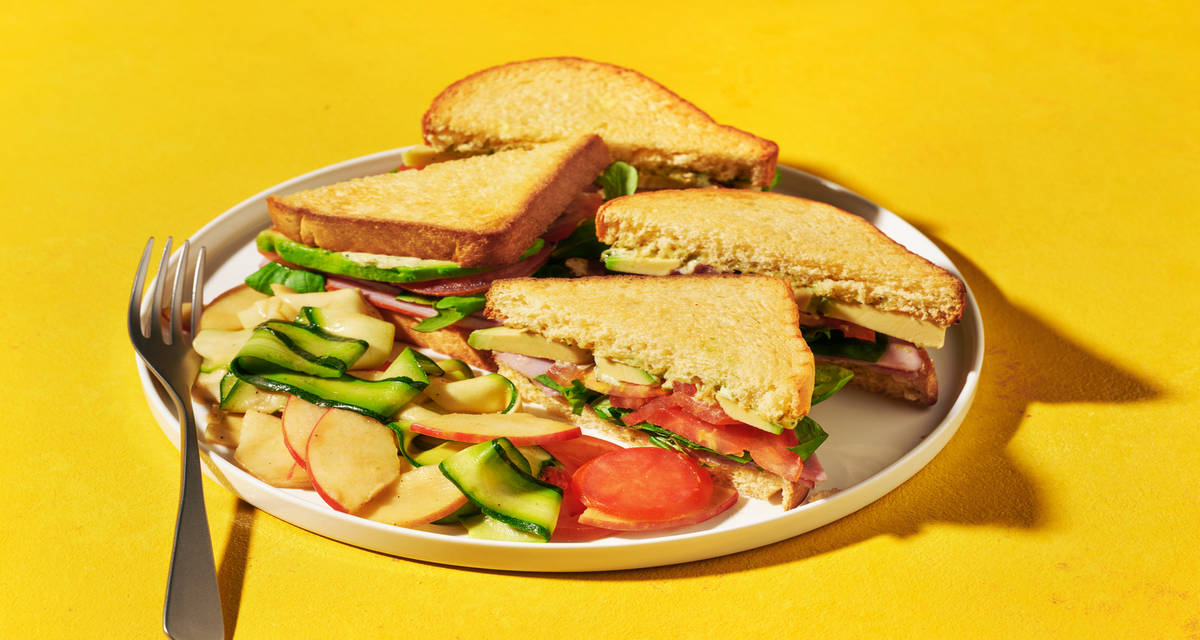 Club sandwich : poulet, avocat & mayo basilic avec une salade croquante pommes-courgettes