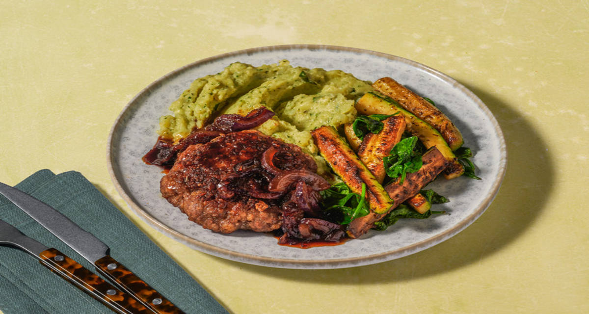 Hamburger met cheesy pesto-aardappelpuree en basilicum met courgette, uiensaus en spinazie