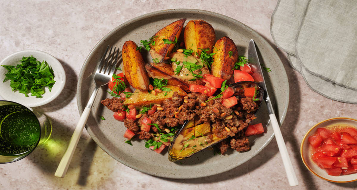Aubergine au bœuf, tahini & pignons de pin pommes de terre à la harissa, tomate et herbes fraîches