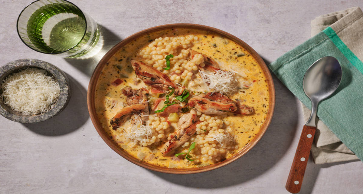 Italiaanse stijl romige kippensoep met Parmigiano Reggiano, basilicum en parelcouscous