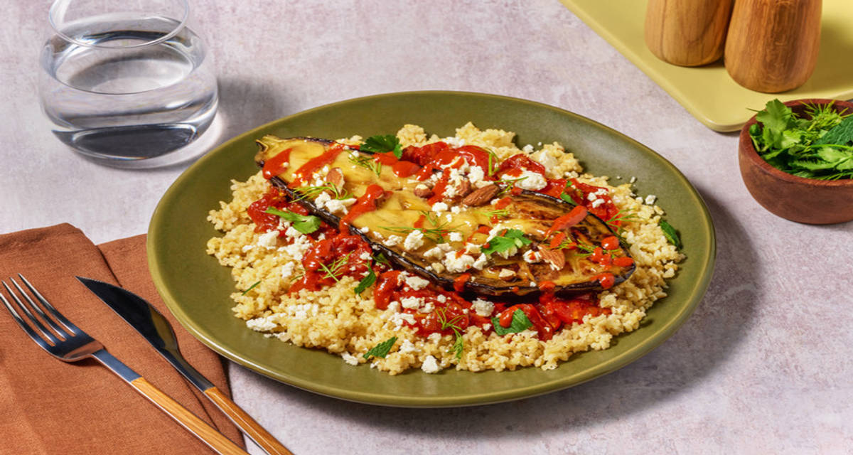 Aubergine laquée au gingembre, feta & harissa boulgour, sauce tomate, amandes et herbes fraîches
