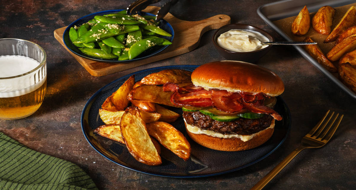 Burger teriyaki au lard sur pain brioché pommes de terre poêlées, pois sugar-snaps et gomasio