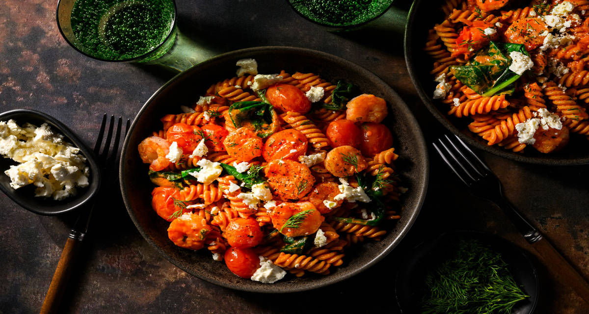 Romige fusilli met garnalen, feta en dille in tomatensaus met spinazie