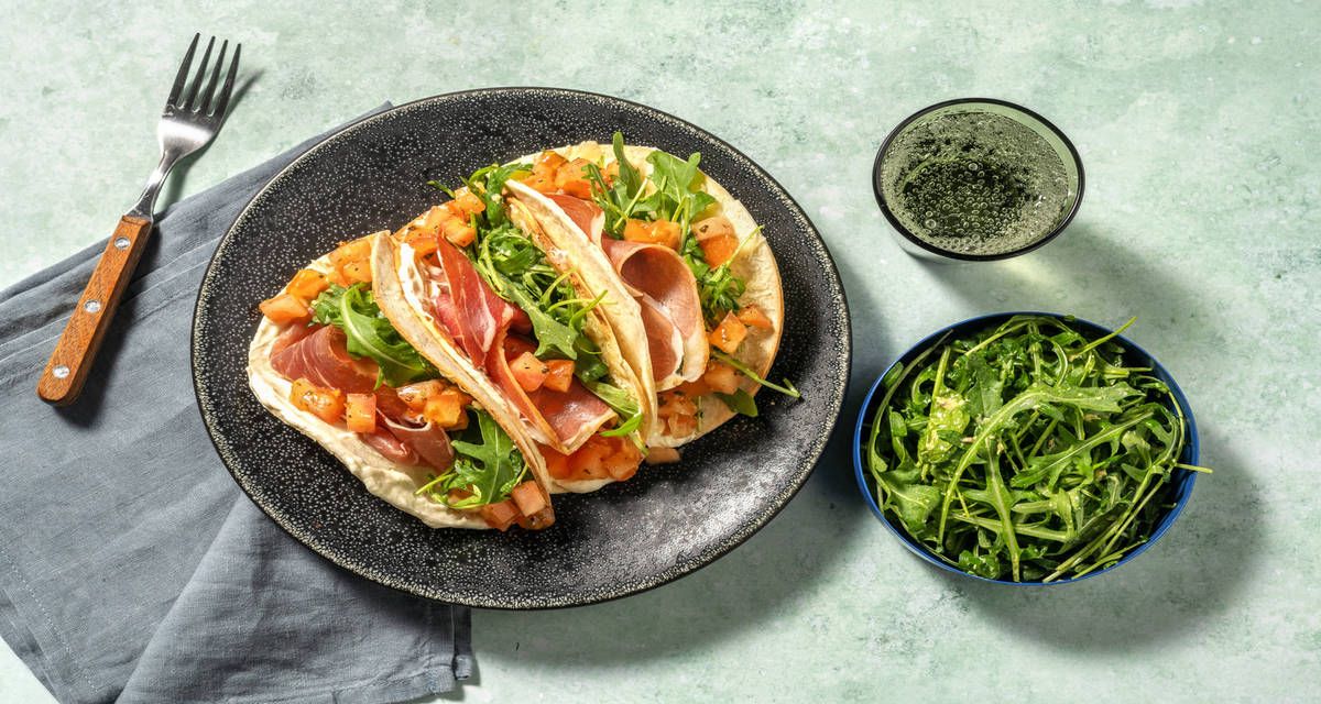 Piadinas de jamón serrano y dúo de quesos con tomate y rúcula en vinagreta de mostaza y avellanas