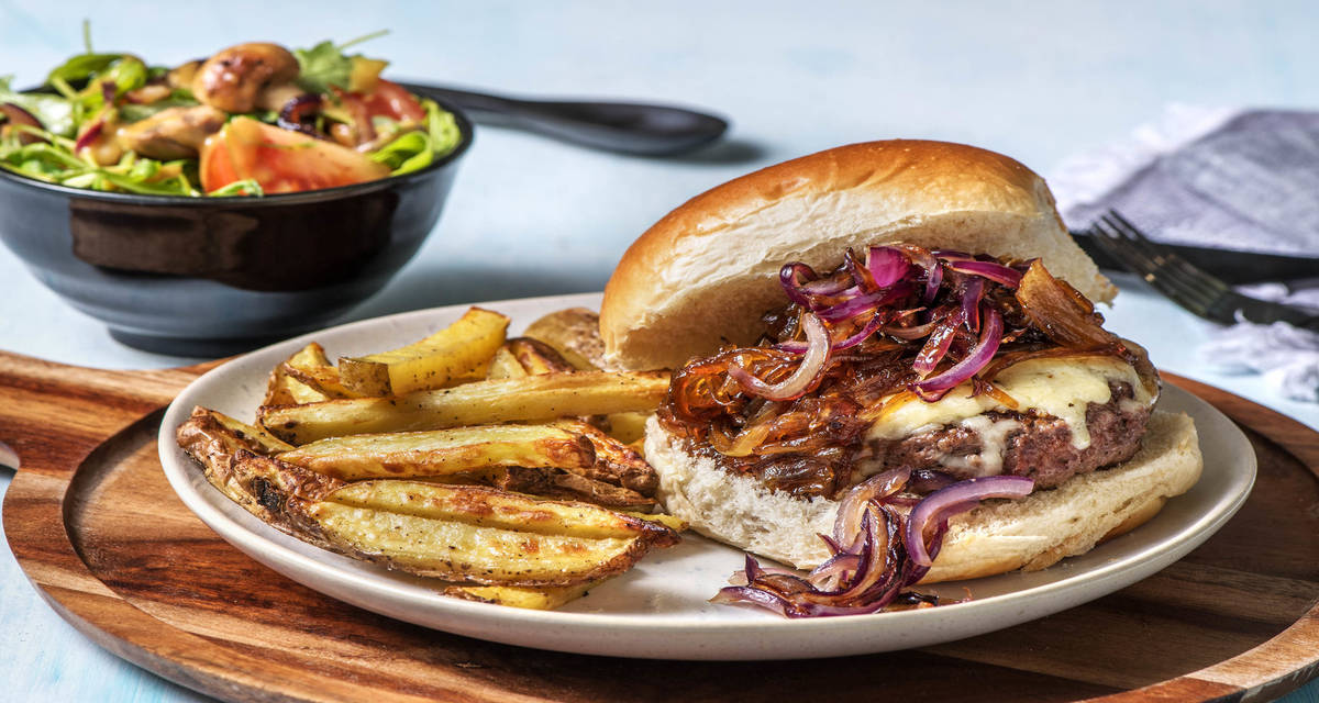 Burger de boeuf au cantal & chutney d'oignon servi avec des frites maison et une salade de champignons
